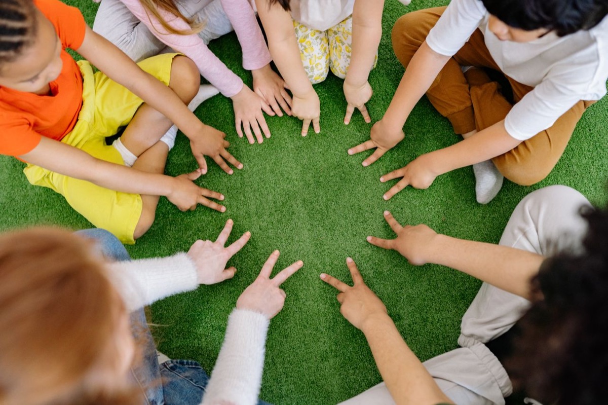 Niños y niñas participan juntos en una actividad sobre césped.